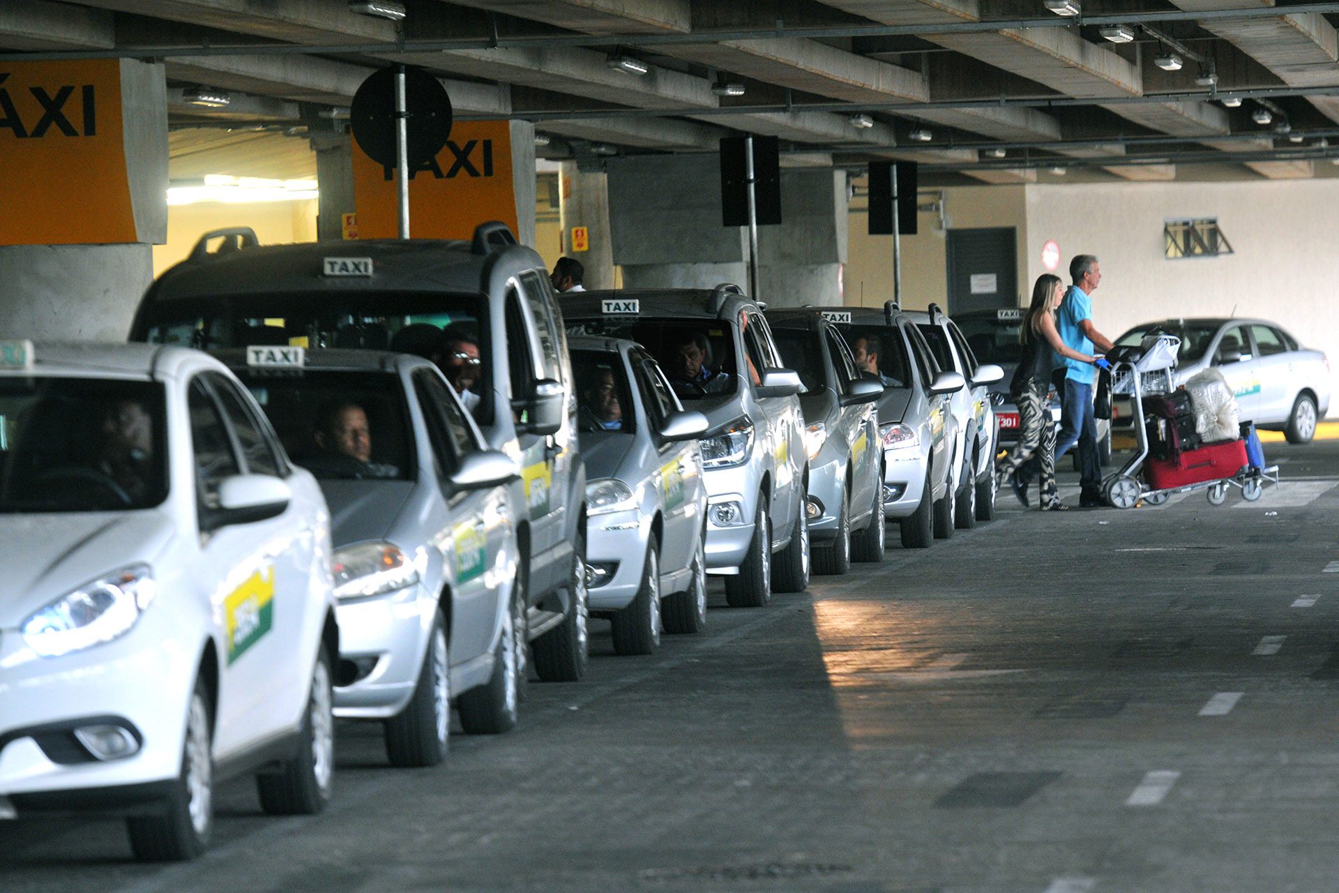 taxi rank white and silver taxis waiting, they all have a signature white taxi sign on their roof