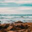 brown rocks, body of water and a cloudy sky
