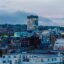 cityscape shot with lighted windows in buildings under a light blue cloudy sky