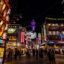 busy square surrounded by lights and signs in Shinsekai, Osaka, Japan
