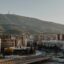 a motorway, city buildings and a mountain at a distance