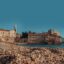 pebble beach and an old castle by the water