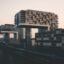 modern quirky looking buildings shaped like the letter 'L' by body of water in Cologne, Germany. Discover this hidden gem as fast as possible by taking a Cologne Airport taxi to the city center.