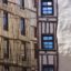 zooming into two unique buildings with various medium sized windows during the day