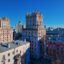 blue sky spreading over mid rise concrete city buildings