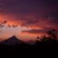 shadows of trees and mountains against a stunning sky with a mix of purple, pink and orange colors