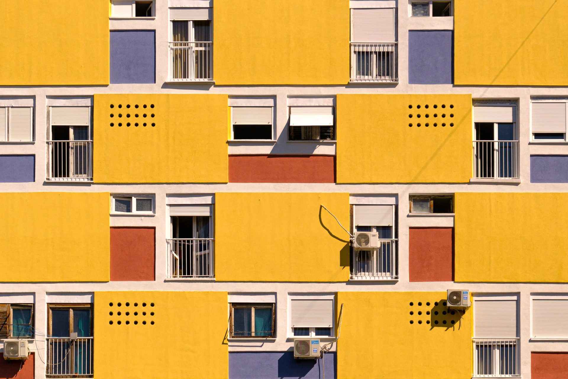bright yellow building with a few bits of contrast color in brick-red, white and blue
