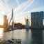 sun shining bright over the city, modern city buildings near body of water