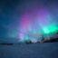 Multi-hued color Aurora captured under a blue sparkling sky