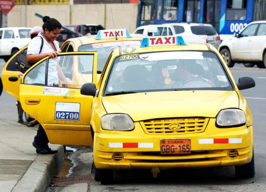 Official yellow taxi in Quito taking a passengers from the street