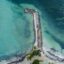 drone shot of seashore with white sand and multiple blue shades of water in Montego Bay in Jamaica