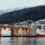 View of cold Bergen houses, mountain and waterfront in Norway. Taking a taxi is one of the fastest way to get from Bergen airport to the city center and start enjoying your vacation right away.