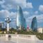 View of Baku city from a viewpoint, showing the Flame Towers, with blue cloudy skies above.