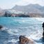 white capped waters crash against rocky cliffs of Naxos under a cloudy sky
