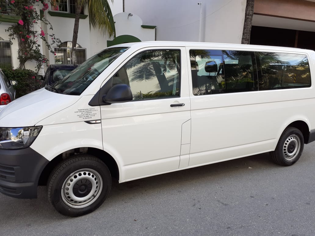 Cancun Airport Taxi (Minivan) A white passenger minivan parked on a residential street, commonly used as a Cancun Airport taxi for groups or travelers needing extra space for luggage, offering pre-booked airport transportation services.