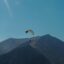 A paraglider coasts downward alongside a mountain in Gudauri, Georgia.