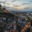 A view of Tbilisi City as the sun is setting with buildings and a church covering a hillside.