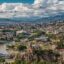 A view of Tbilisi with houses, trees and building along a river in a valley