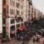 A bustling daytime view of Istiklal Street in Taksim, Istanbul, filled with hundreds of pedestrians walking past historic European-style buildings, shops, and cafes. The lively atmosphere showcases one of the city’s most famous avenues, a must-see for travelers arriving via IST Airport to Taksim.