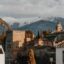 A view of the top of Granada's traditional buildings with mountains behind and clouds above.