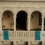 A colonial-style balcony with three Guatemalan flags hanging over the railings.