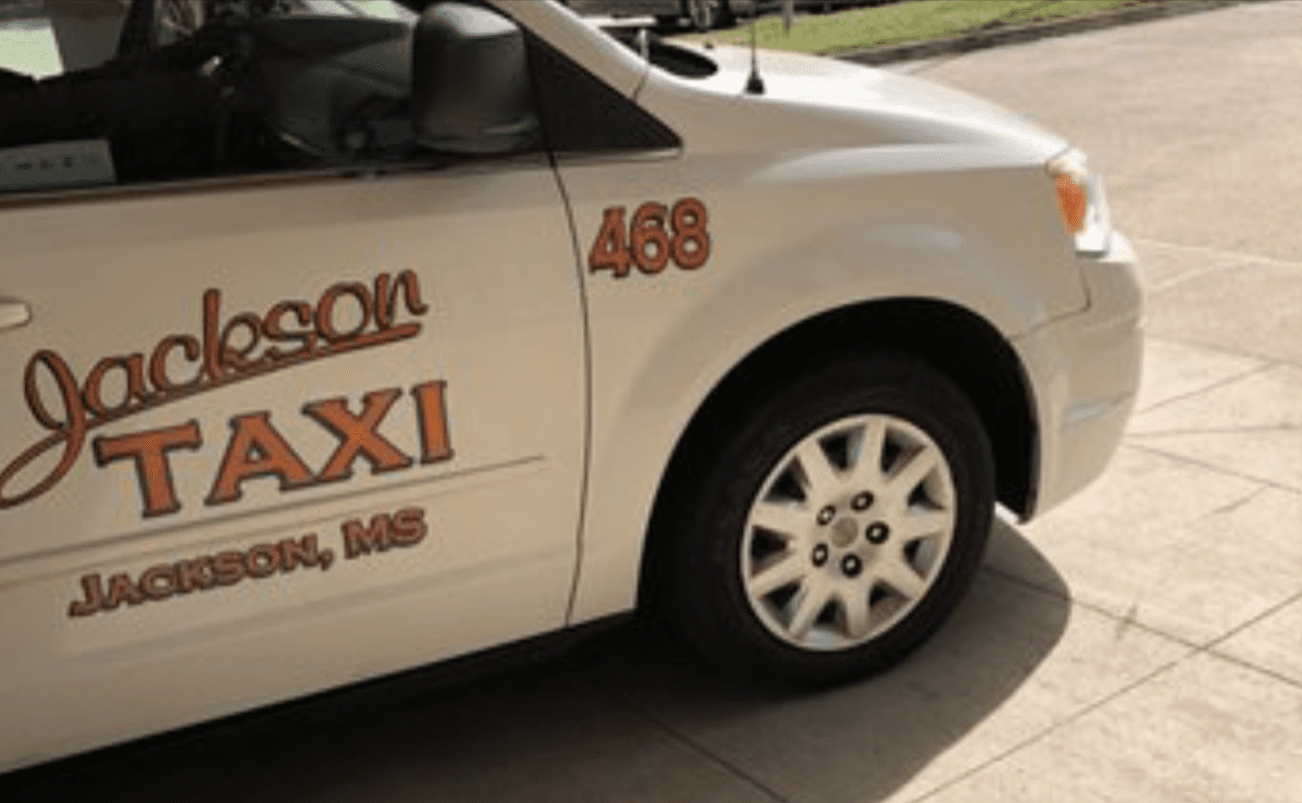 A white Jackson taxi with orange lettering on the door.
