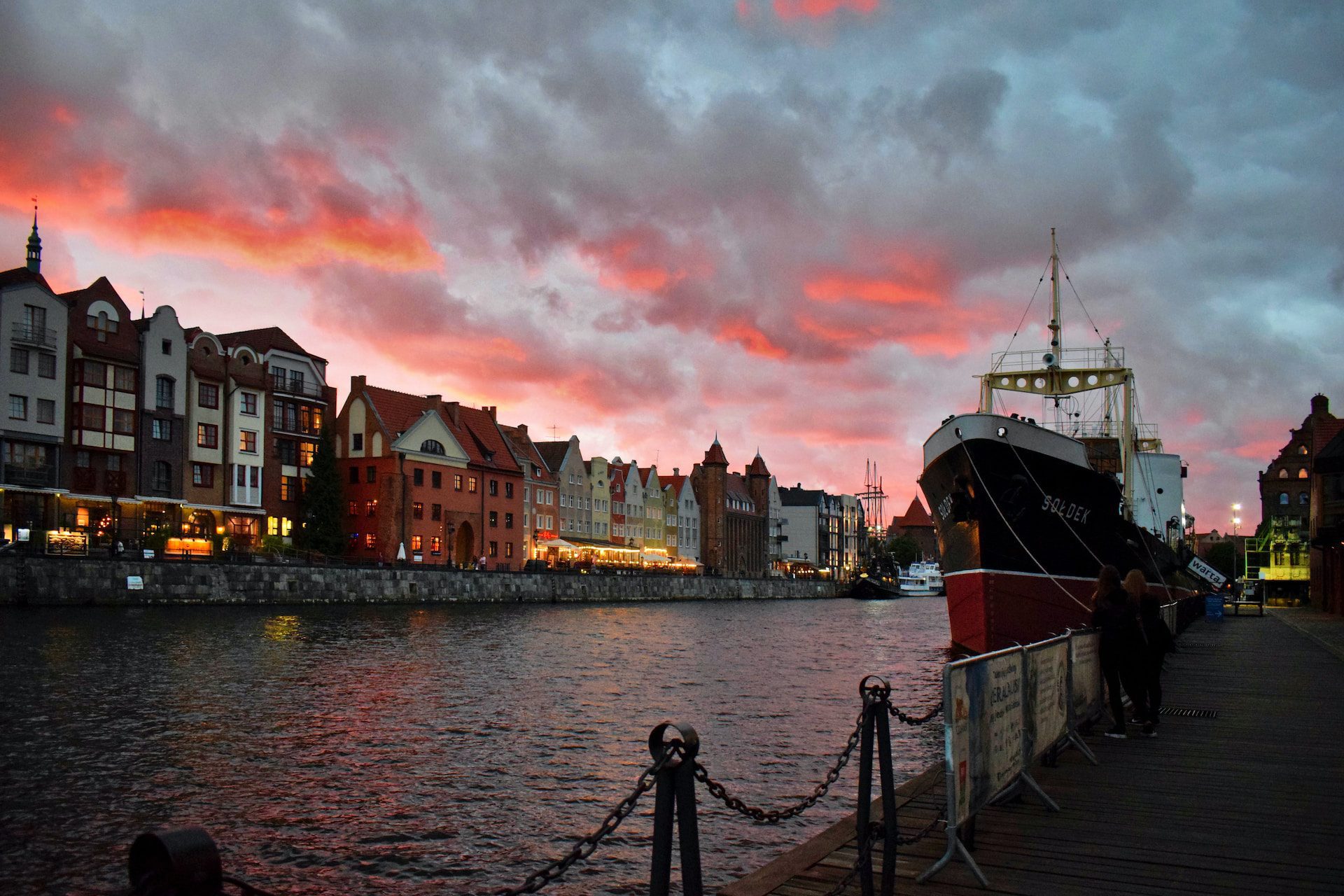 Pink cloudy sunset over the channel and homes in Gdansk, Poland.