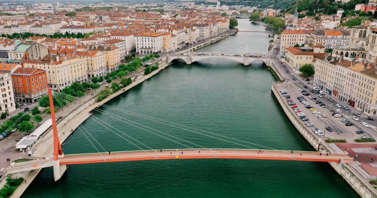 bridges over green colored water with streets and buildings on both sides