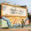 Photo of a billboard with a colourgul mural underneath in Maputo city.