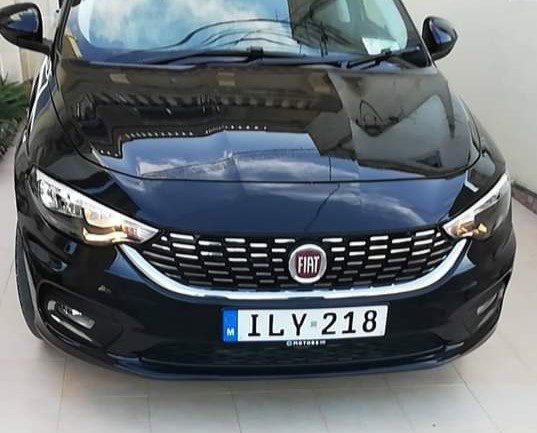 The front end of a black Malta taxi