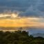 The sun setting through the clouds over the cloud forest in Monteverde