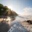 The sunlight hitting a small ocean inlet through the trees in Santa Teresa