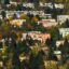 Colourful buildings and houses set within a tree covered hillside.