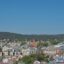 The beautiful town of Haugesund rests below a hillside with peaked roofs and trees.
