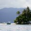 Serene waters with palm trees and mountains off the coast of Port Barton, Philippines.