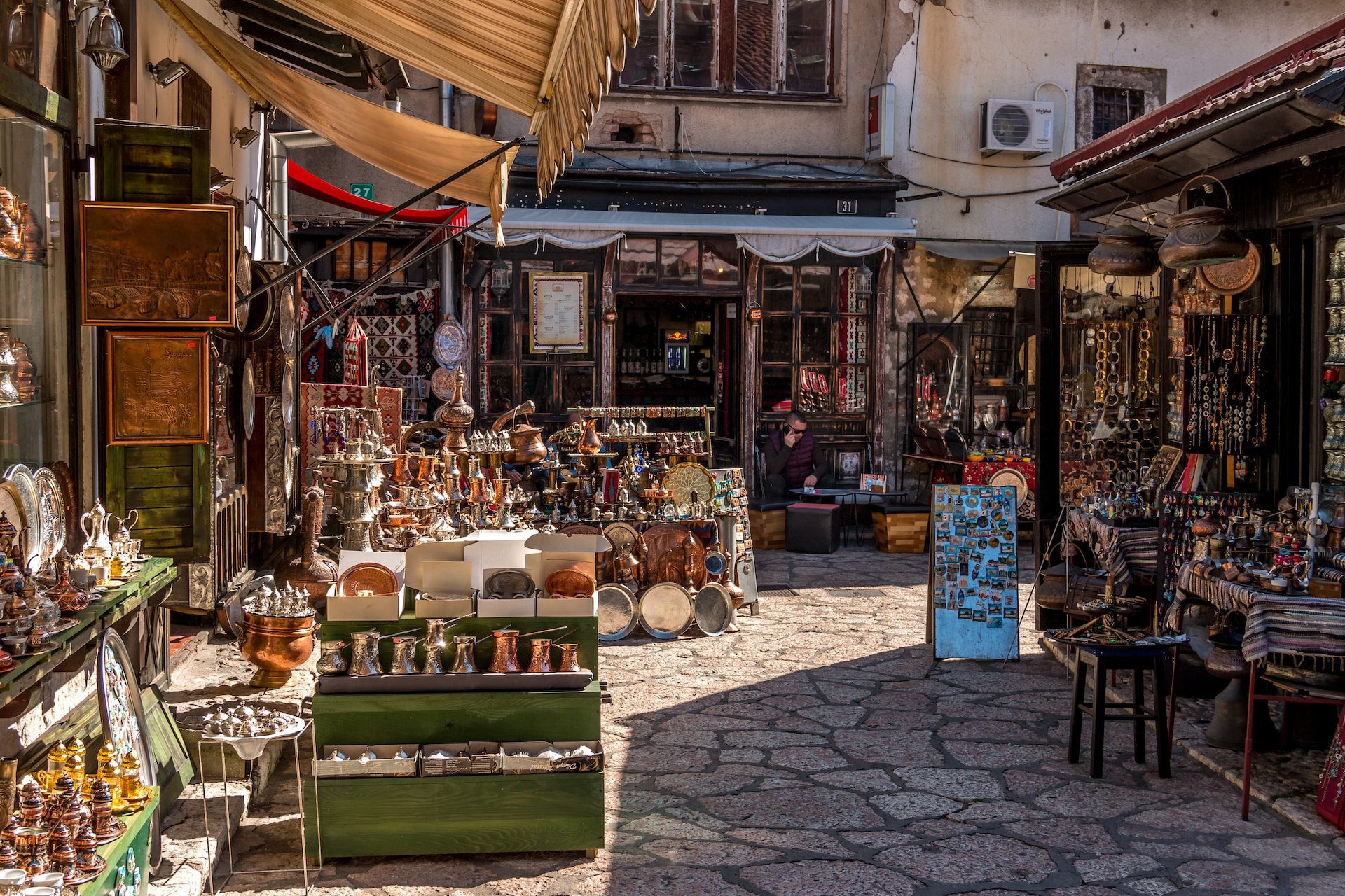 Sarajevo market with stores lining a cobble stoned path.