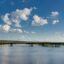 A long bridge stretching across a clear and calm waterway with trees on either side.