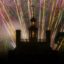 Fireworks stream through the sky behind Colonial Williamsburg building