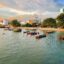 Beautiful coast of Butterworth, Malaysia lined with boats, buildings, and sandy beach.
