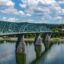 A panoramic view of Chattanooga, with the bridge crossing the river and green hills in the background.
