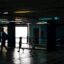 Silhouettes of a man and two small children walking through a Girona public transport station.