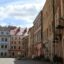 A street in Lublin lined with old colourful buildings in pastel colours of yellow, peach, pink and blue.