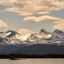 Snow covered mountains under a cloud-spotted sky in Molde, Norway.