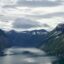 Scenic view of mountains and water under a sunlit cloudy sky in Molde, Norway.