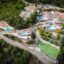 High aerial view of resorts in Nidri, Greece surrounded by trees.