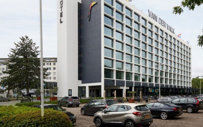 The front view of the Van der Valk Hotel in Antwerp with cars parked in front