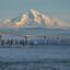 Mountain behind a bridge over water in a hazy sky.
