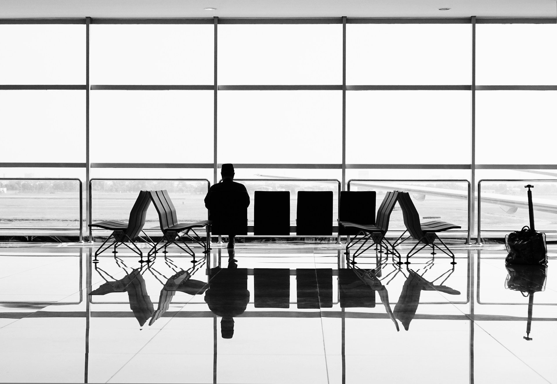 Waiting seats in front of large glass windows at the airport.