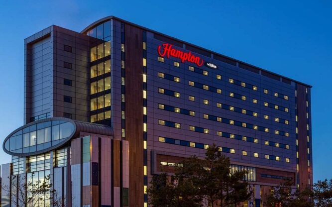 The front view of the Hampton by Hilton Liverpool Airport Hotel at night.