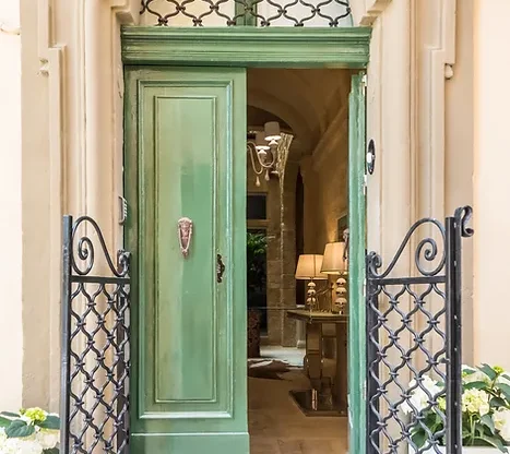 An old pastel green door that serves as the entrance to the Casa Birmula Hotel near Malta Airport (MLA)